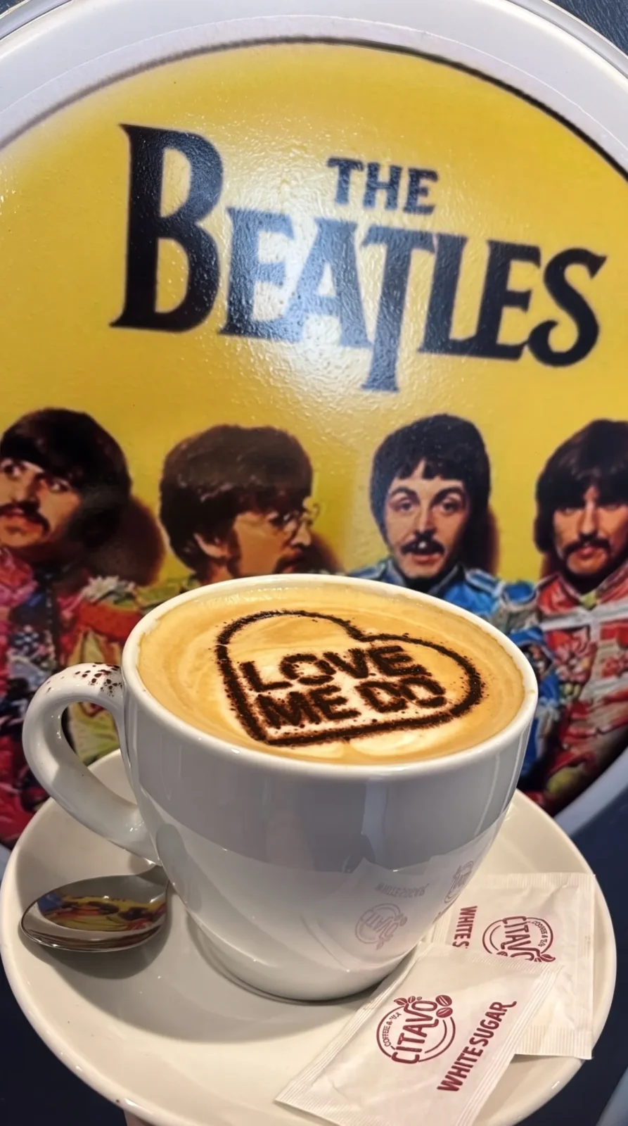 Cappuccino with LOVE ME DO latte art in front of the Beatles