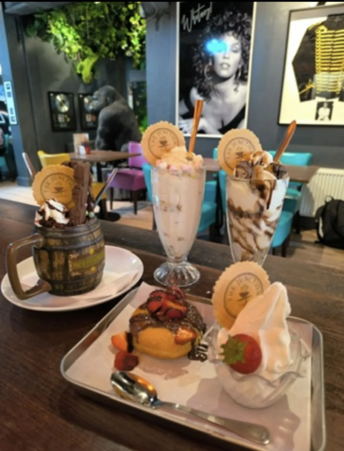 Milkshakes and desserts on a table by the rock wall