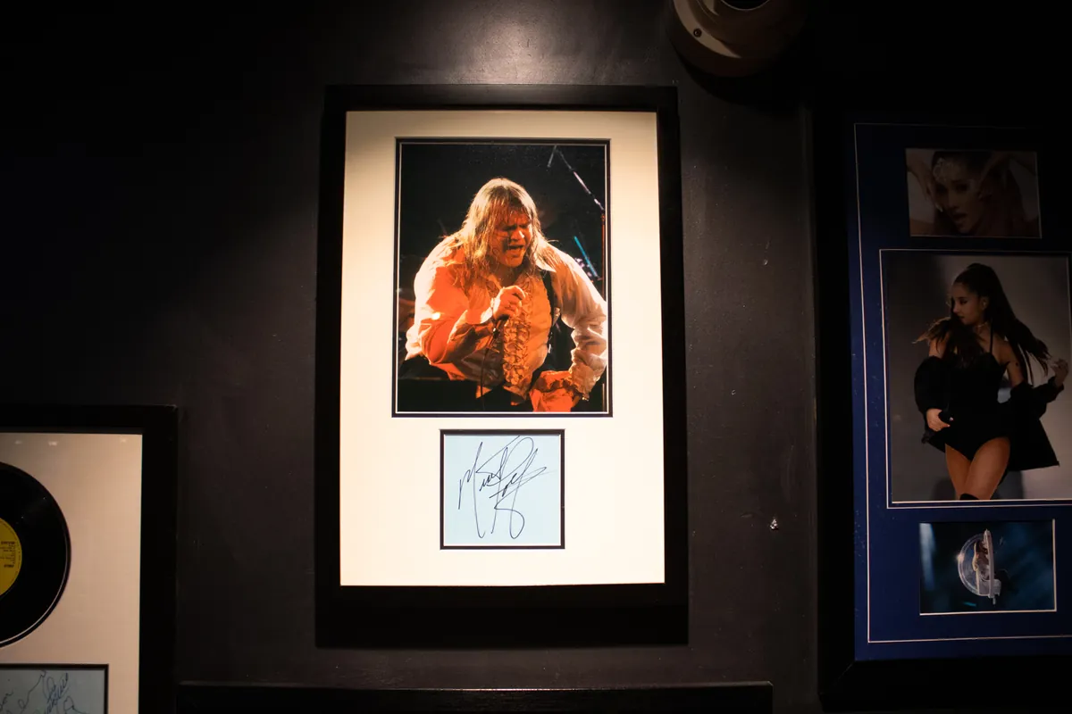 A live shot framed with a signature card below it.