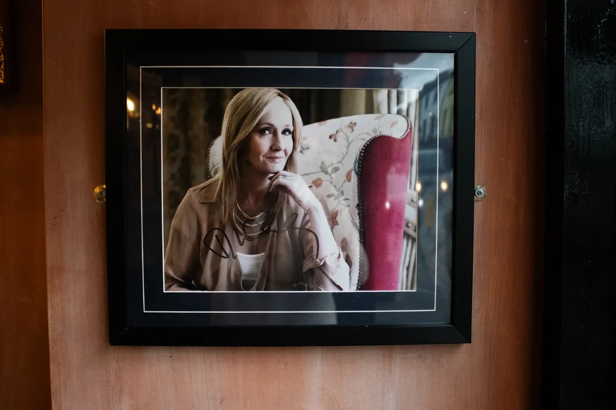 A portrait of J.K. Rowling in a gilt-edged frame.