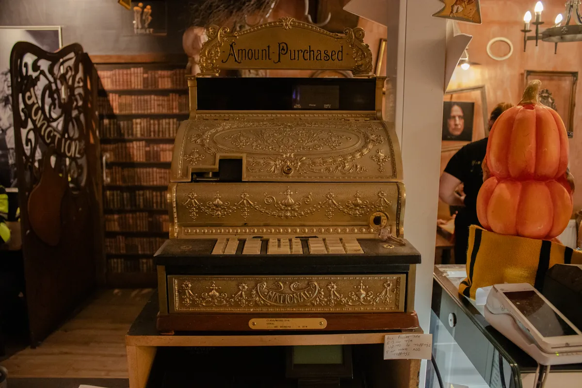 An ornate brass cash register, still standing at the counter.