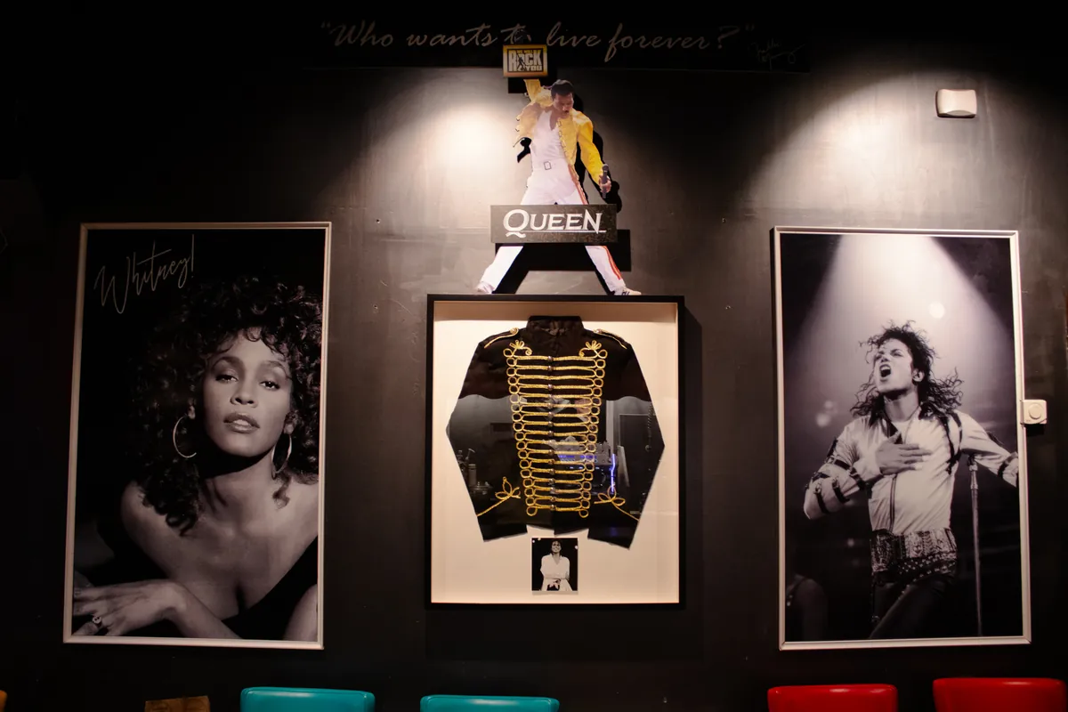 Whitney Houston and Michael Jackson either side of a Queen stage jacket in a shadow box.