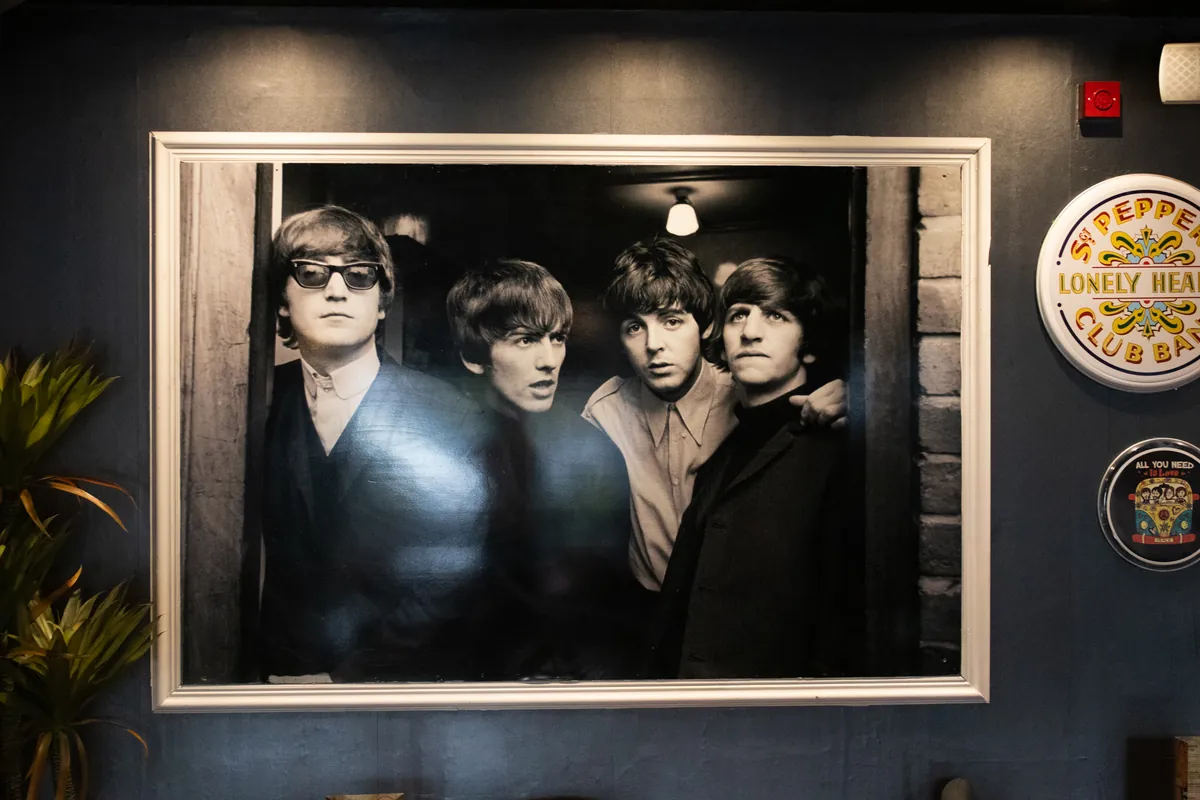 A big black-and-white Beatles print beside a Sgt. Pepper drum sign.