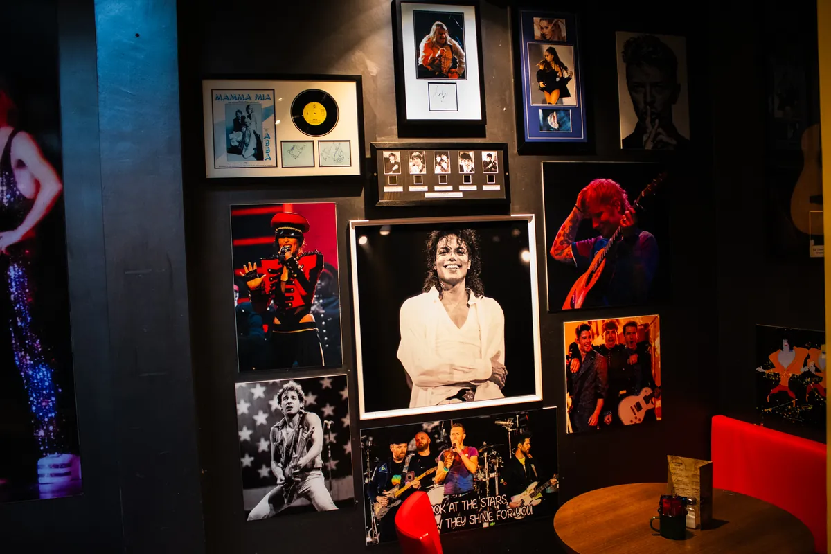 Floor-to-ceiling frames: stage shots, records and posters from decades of pop and rock.
