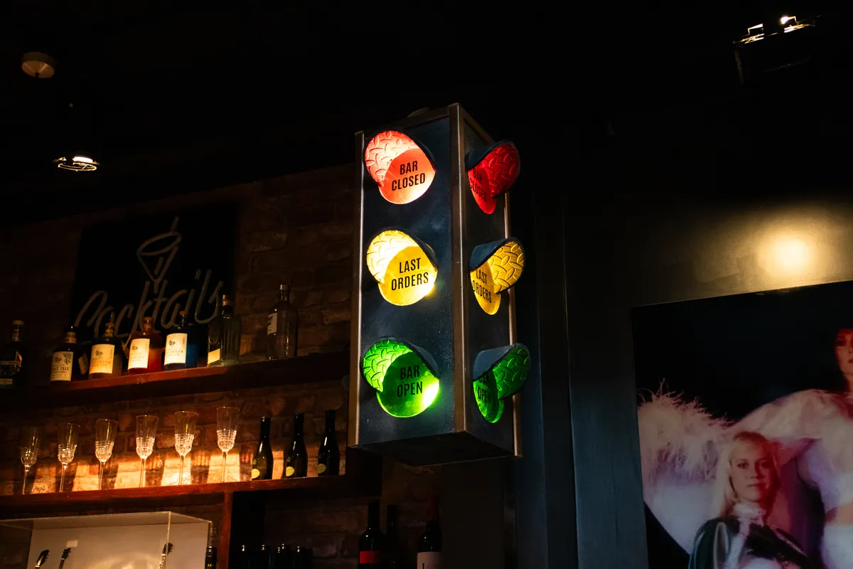 A real traffic light behind the bar: green for bar open, amber for last orders.