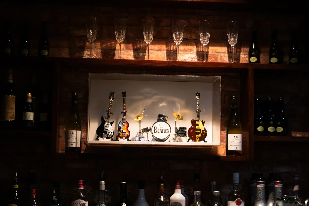 Miniature guitars and a Beatles drum kit on the back bar.